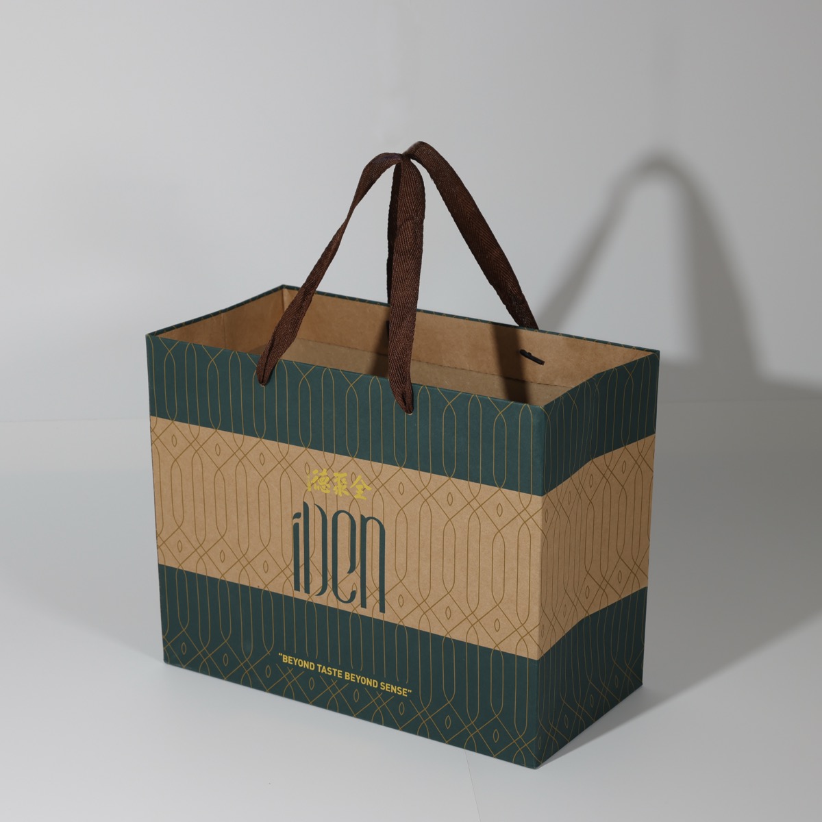 iDen tea — green and kraft luxury paper bag with gold line pattern and woven ribbon handles